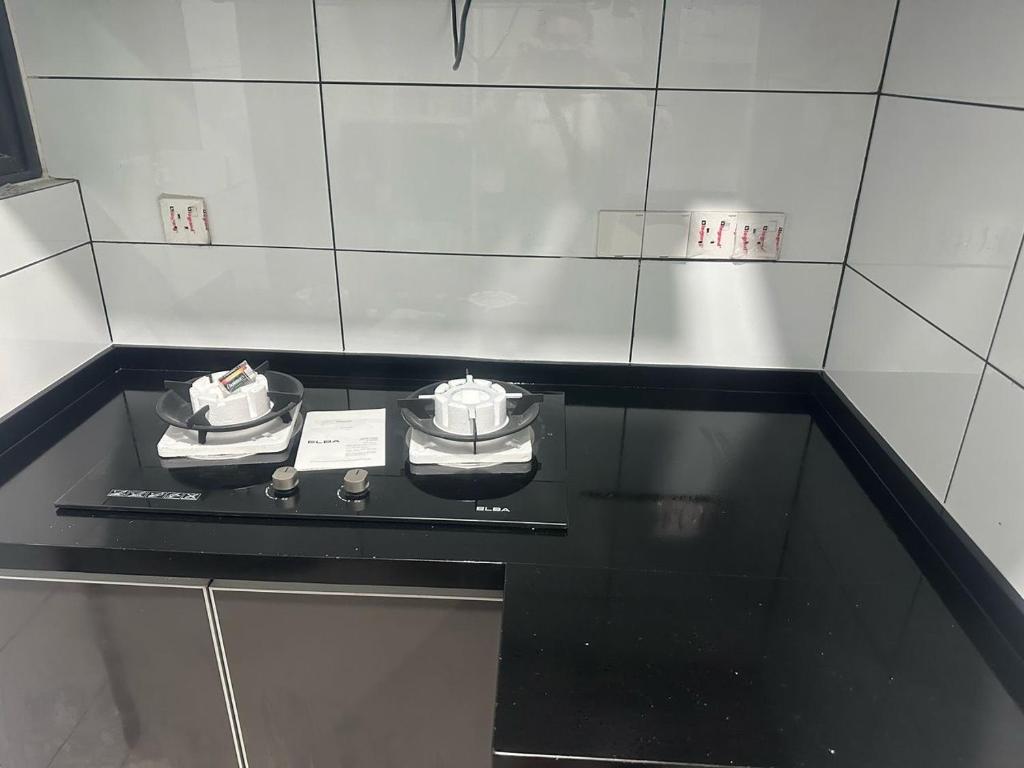 a black counter top with two clocks on it at The Valley, SkySierra KL in Kuala Lumpur