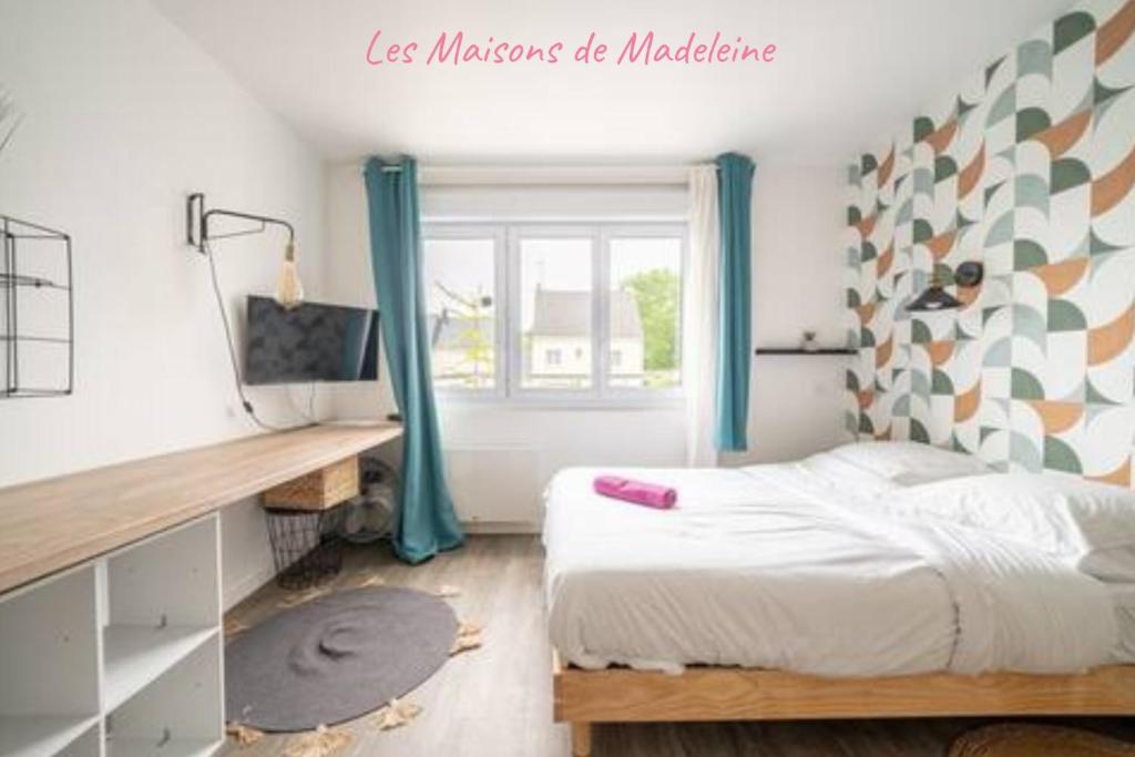 Un dormitorio con una cama y un escritorio y una ventana. en Les studios de l'Albatros, en Saint-Nazaire