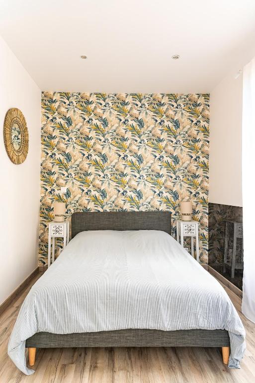 a bedroom with a bed and a floral wallpaper at Villa Mona Studio Galets quartier des Cordiers in Le Tréport
