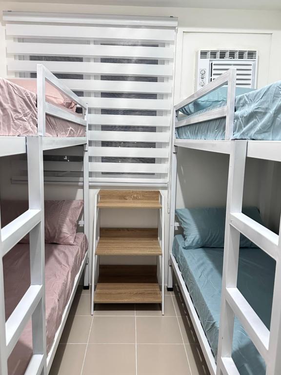 a room with three bunk beds and a couch at Covent Garden Condominium in Manila