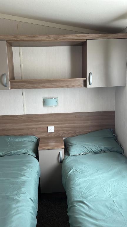 two beds sitting next to each other in a bedroom at Heysham Coastal Escape Family 3-Bed Caravan in Heysham