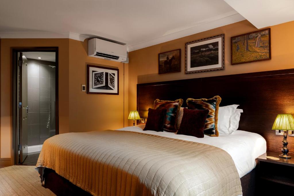 a hotel room with a large bed and two lamps at Rose And Crown Hotel in London