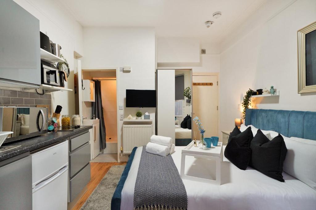 a living room with a couch and a kitchen at Central Harrow Studios 3mins to station! in Harrow