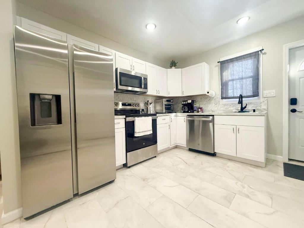 a kitchen with stainless steel appliances and white cabinets at Town & Country Andover NJ Area-1st Floor 2 Bedroom in Newton