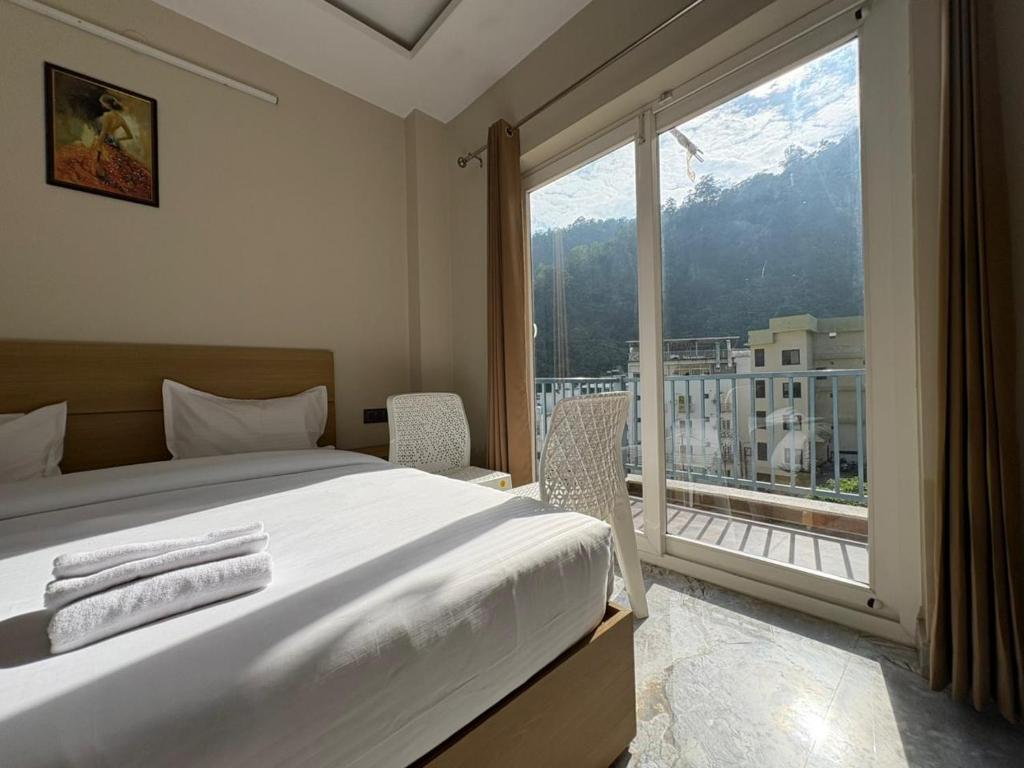 a bedroom with a bed and a large window at Hotel Abline the Oaks in Rishīkesh