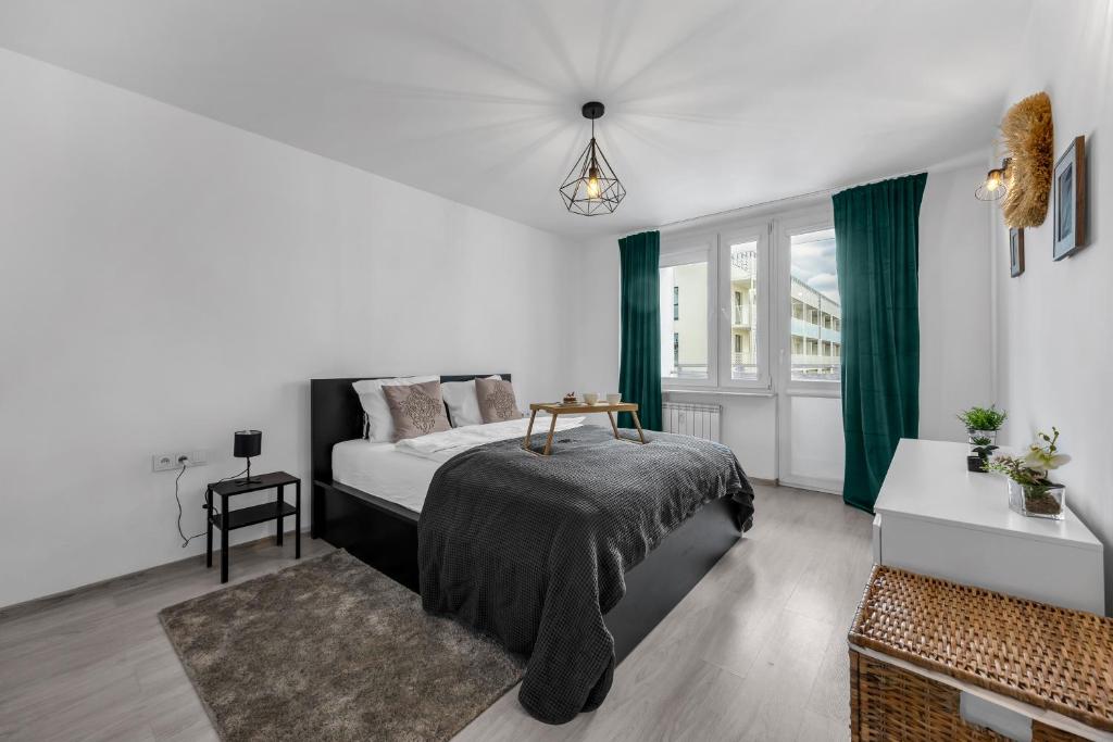 a white bedroom with a bed and a window at Gocław Apartment - 48m2, Balcony - by Rentujemy in Warsaw