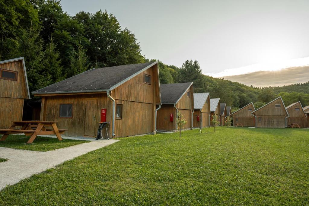 a row of wooden barns in a field of grass at The Cabin Retreat Piešťany 