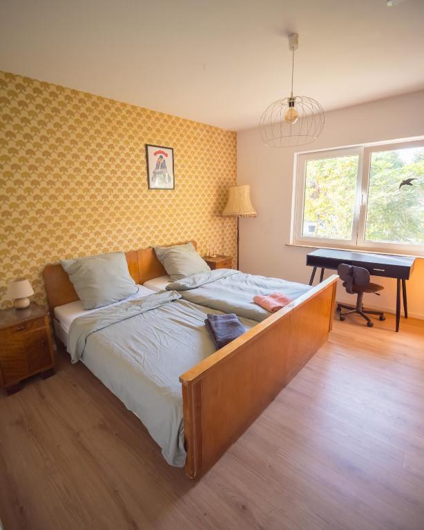 a bedroom with a bed with a desk and a piano at 70er Bungalow in Farven