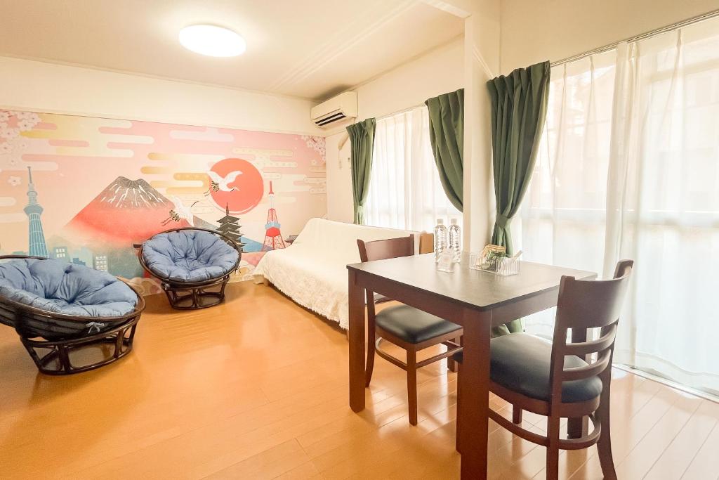 a bedroom with a bed and a table and chairs at Wisteria102 無料駐車場有 JR春日井駅徒歩3分の宿 in Kasugai