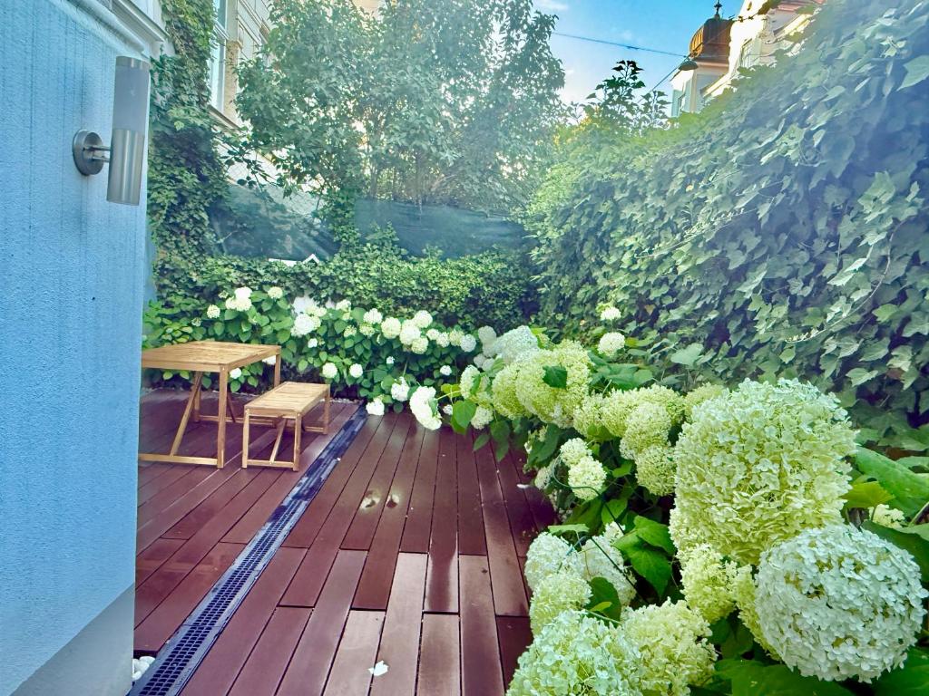 een patio met een tafel en een bos bloemen bij Luxury 130 m2 Apartment with Garden in Wenen