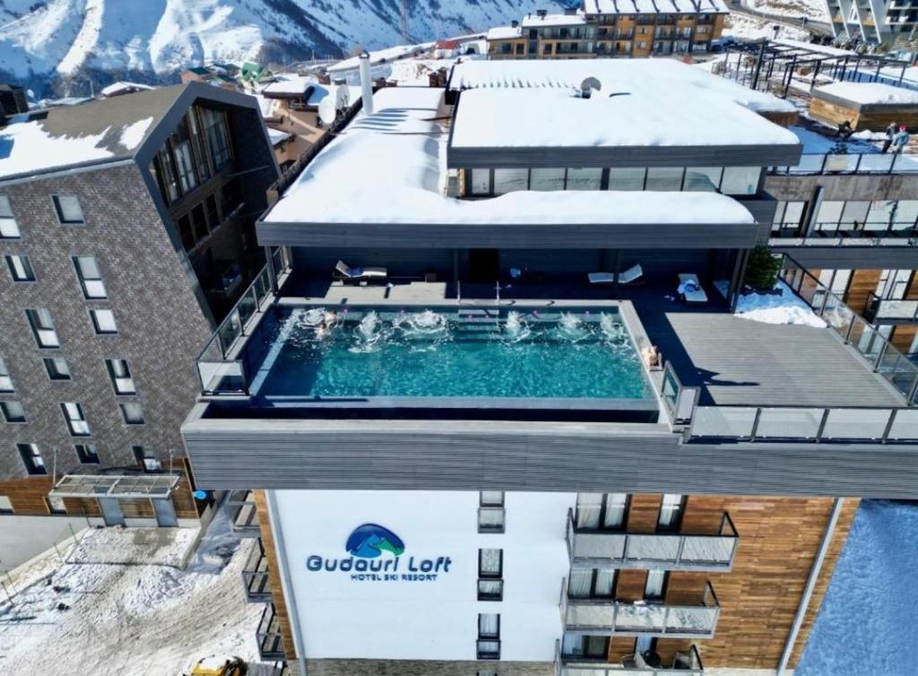 una vista dall'alto di un edificio con piscina di Ski In Ski Out Tiamo apartment 402 at Gudauri Loft Hotel a Gudauri