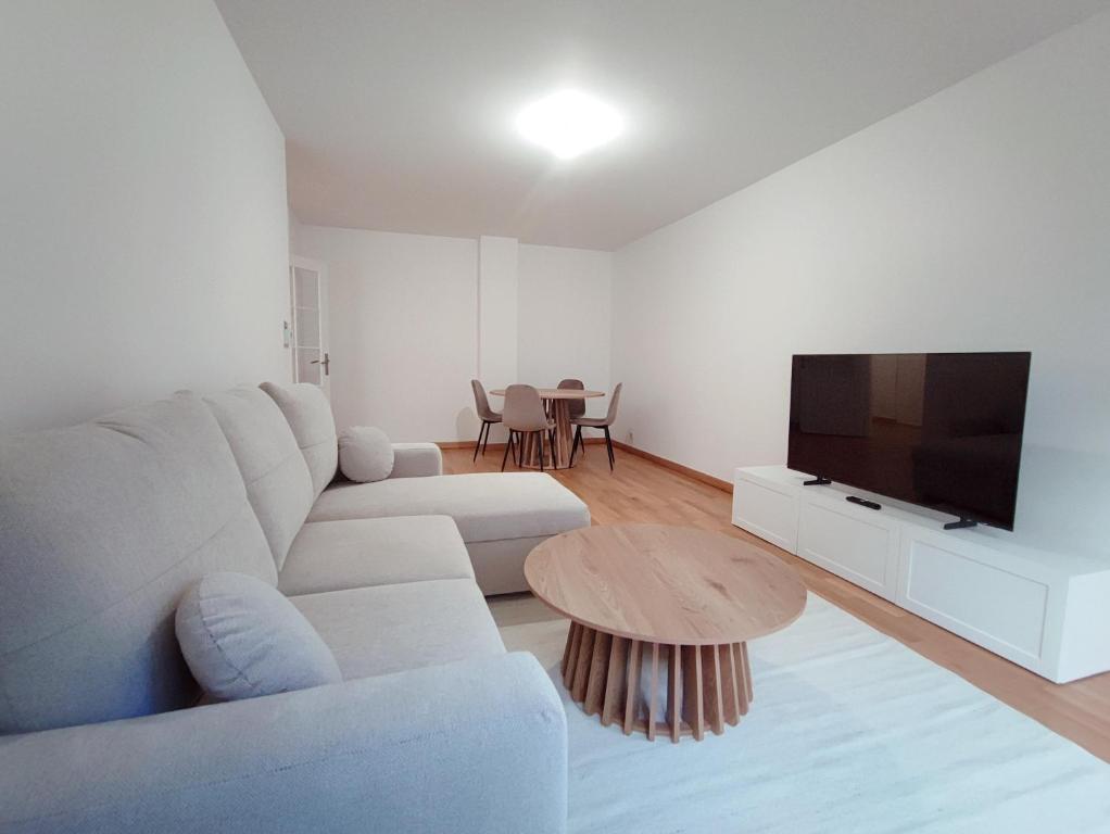 a white living room with a white couch and a table at Charming 3 rooms with parking in Rueil-Malmaison