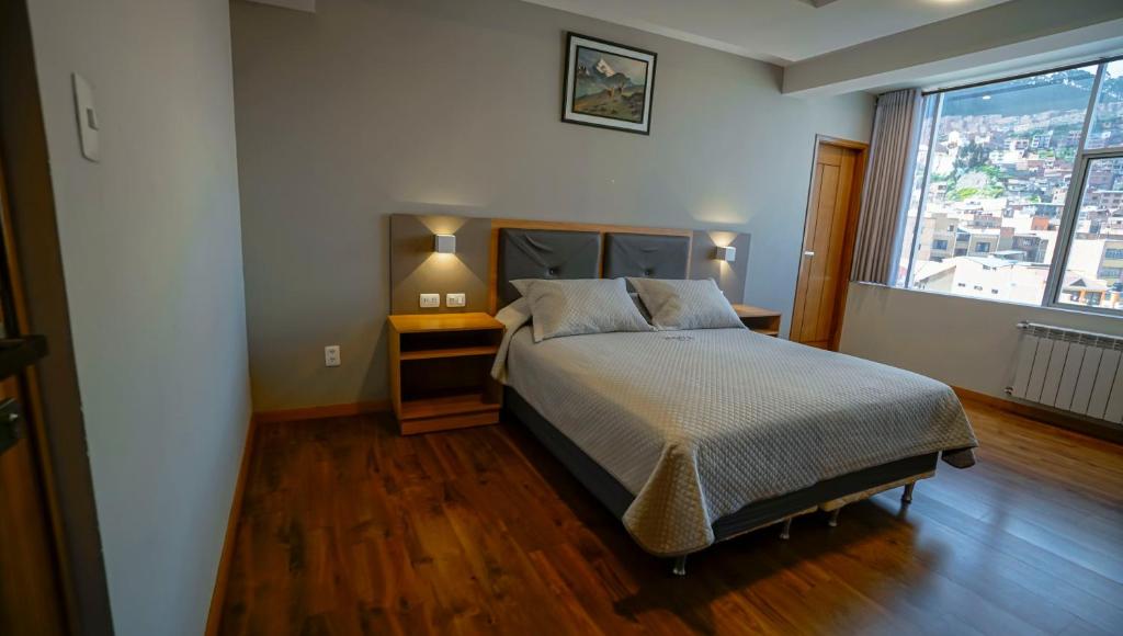 a bedroom with a bed and a large window at Hotel Nova La Paz in La Paz