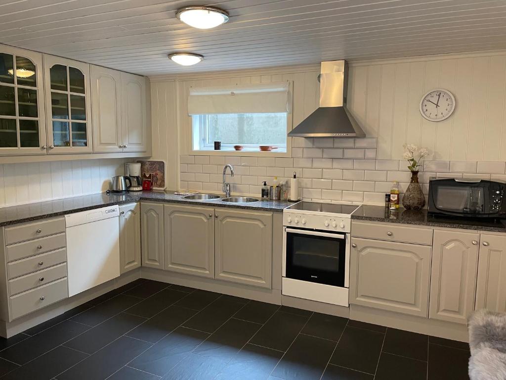 a kitchen with white cabinets and a sink and a stove at Villa Valberg in Sarpsborg