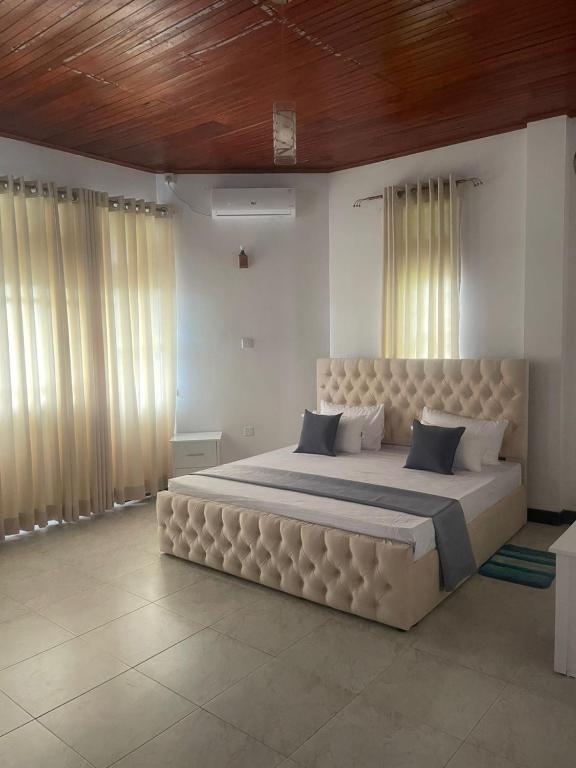 a bedroom with a large bed with a large headboard at Peak Lodge in Kandy