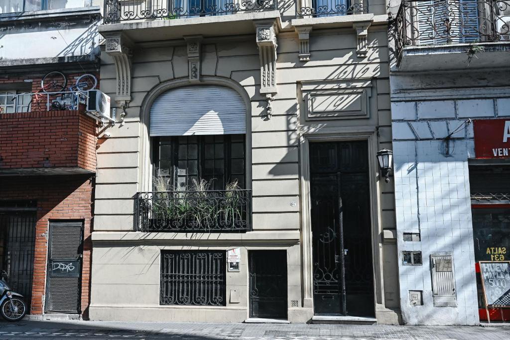 a white building with a balcony and a window at Habitaciones Temporarias CABA in Buenos Aires