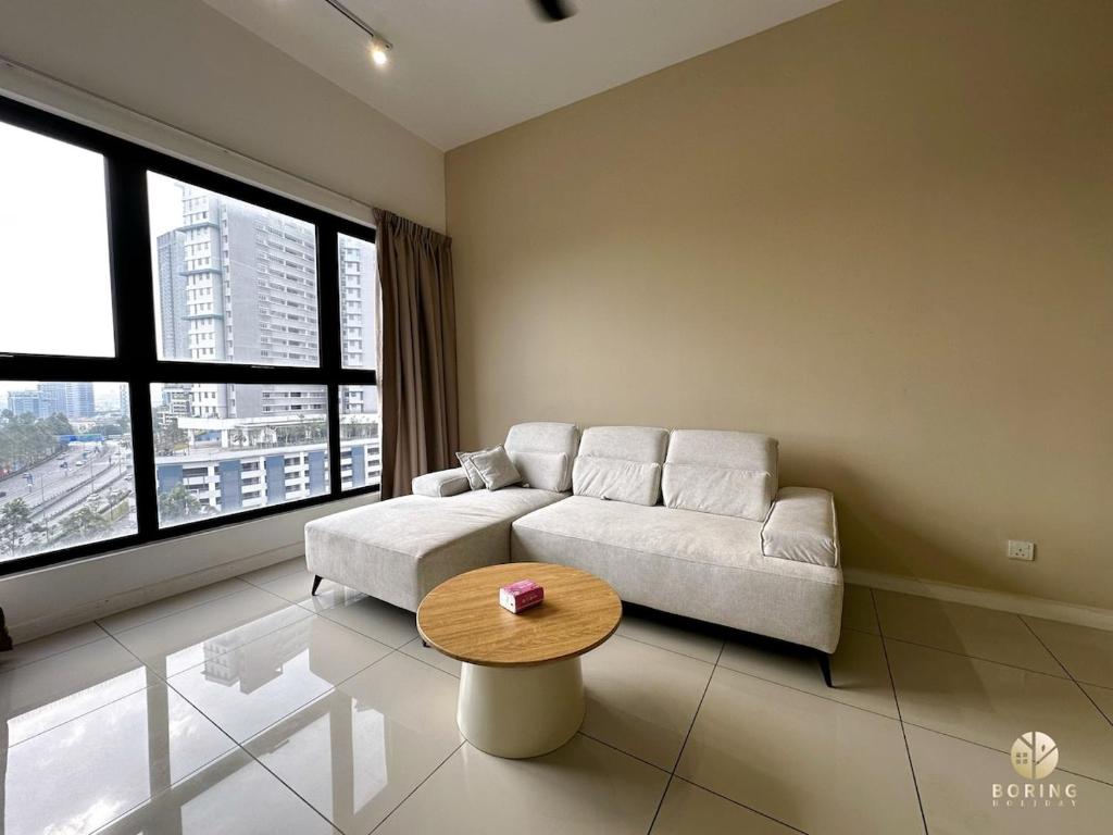 una sala de estar con un sofá y una mesa en NEW Le Pavilion Puchong 8-10pax 3R2B, en Puchong