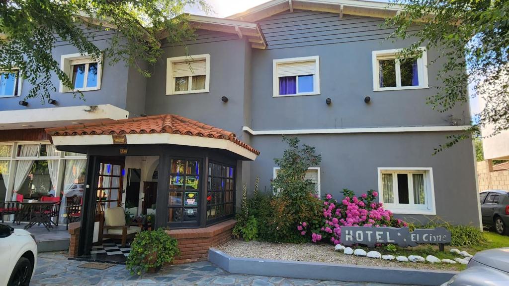 Una casa con entrada de hotel y flores. en Hotel El Cisne, en Villa Gesell