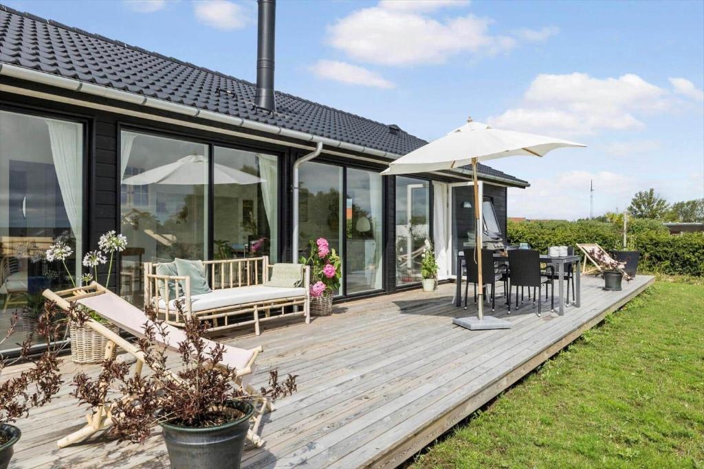 a wooden deck with chairs and an umbrella at 6813-Allinge-Aeblebakken-5 in Allinge
