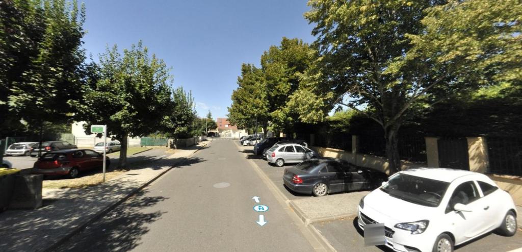 un coche blanco estacionado al lado de una calle en Cozy appart between Paris & Disney, en Torcy