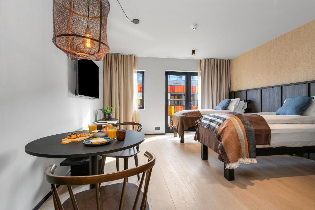 a hotel room with a bed and a table and a bed at Strand Hotel Apartments in Hafnarfjördur