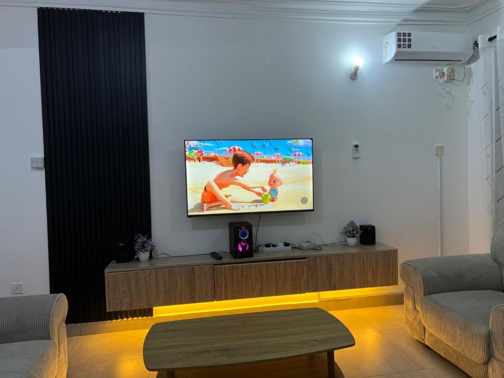 Una sala de estar con un televisor de pantalla plana en una pared. en Elite Luxury 2bedrm Nyali, en Mombasa