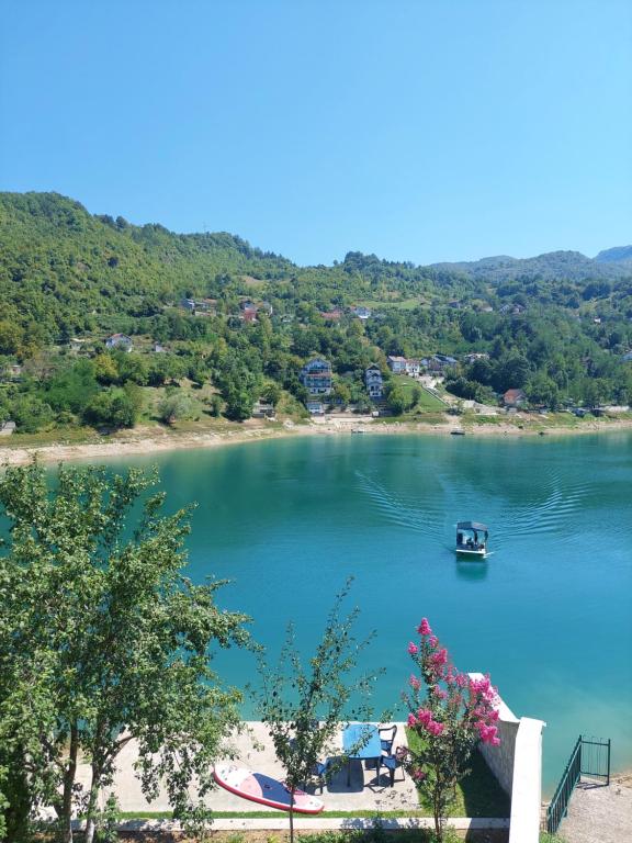 a lake with a boat in the water at Apartman AS na jezeru in Konjic