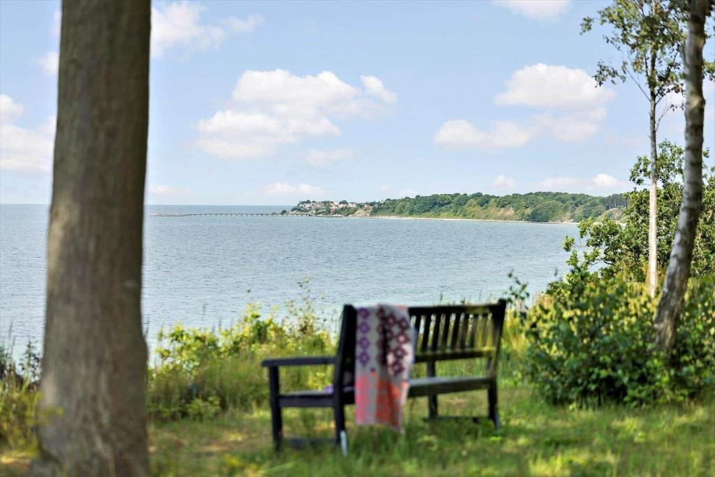 a park bench sitting next to a body of water at 4705-Aakirkeby-Sondre-Landevej-60 in Åkirkeby