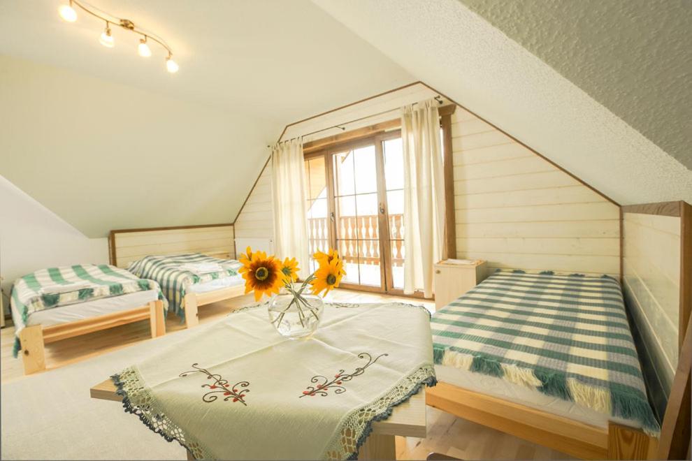 Pokój z dwoma łóżkami i wazą ze słonecznikami w obiekcie Ośrodek Szkoleniowy Za Lasem w Sycowie