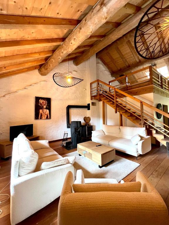 CharchillaにあるGîte Les Plaisirs du Lac avec spa & jacuzziの白い家具と木製の天井が備わるリビングルーム