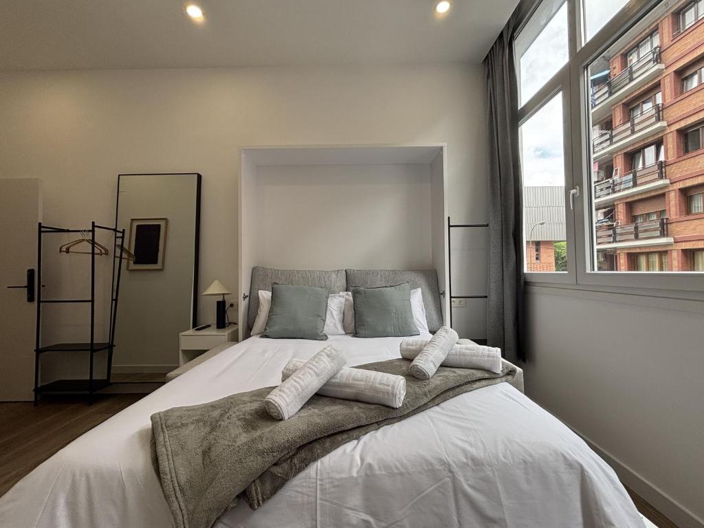 a bedroom with a large bed with a large window at Gabika Apartment 2 in Bilbao