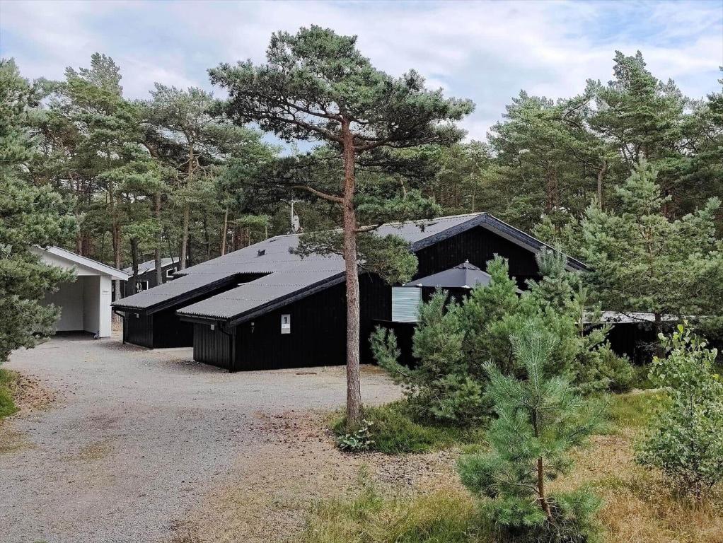 a black house in the middle of a forest at 2512-Nexo-Rokjinkan-7 in Vester Sømarken