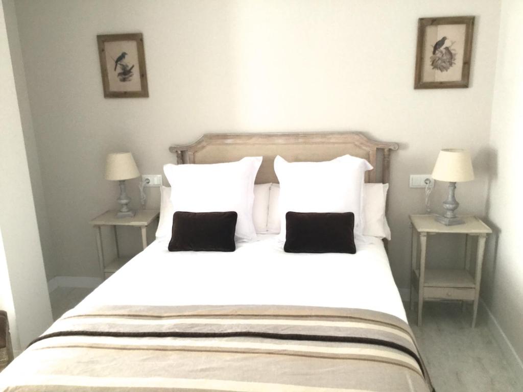 una camera da letto con un grande letto bianco con due tavoli di Morendal-Zaaita a Soria