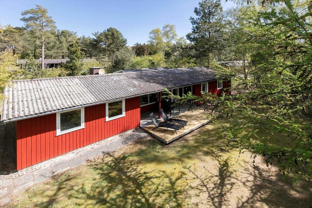 eine Aussicht auf ein rotes Haus im Wald in der Unterkunft 1512 Aakirkeby - Bjælkeåsen 3 in Vester Sømarken