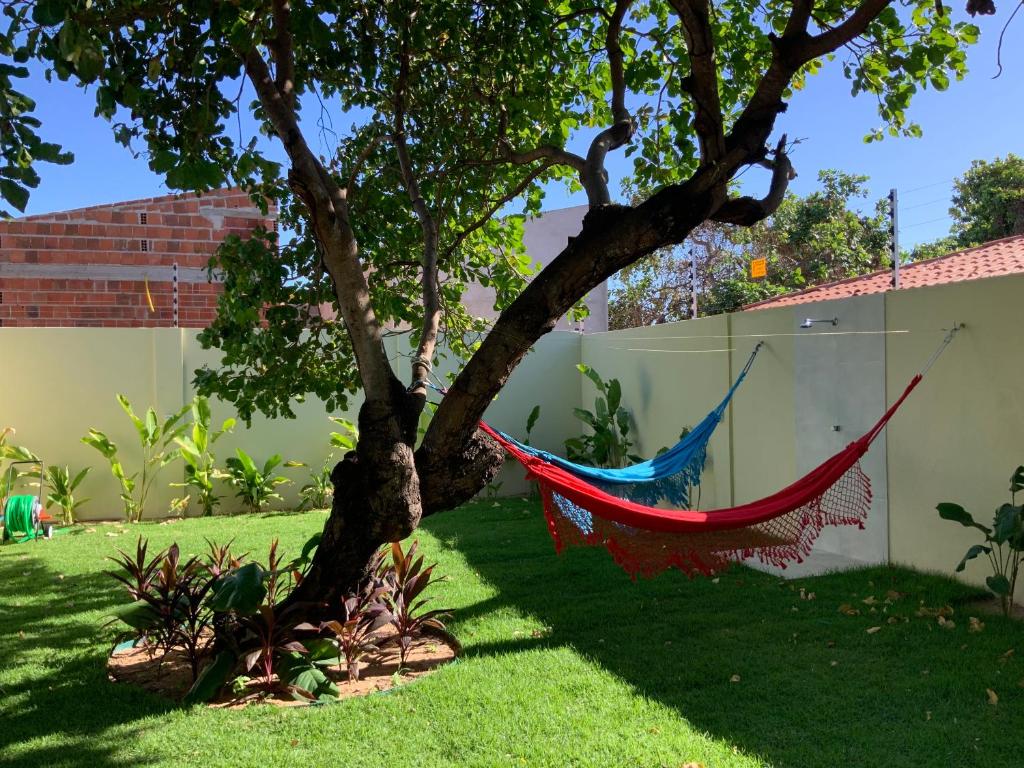eine Hängematte, die von einem Baum im Hof hängt in der Unterkunft Casa dos cajueiros in Paracuru