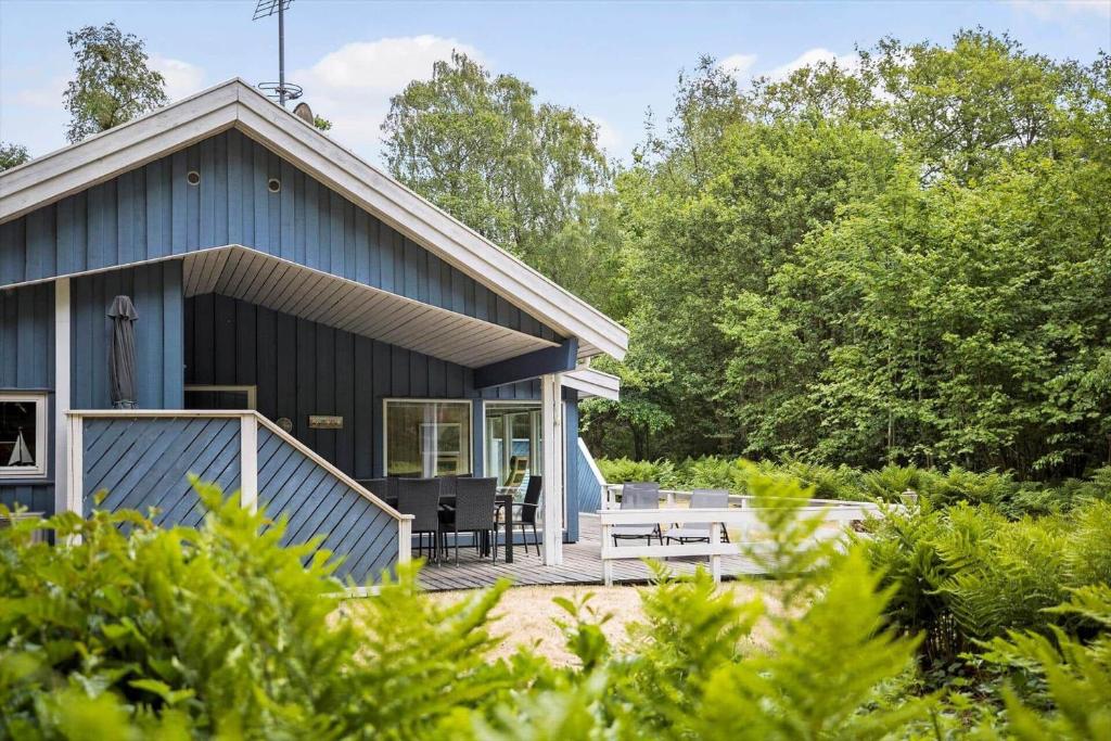 ein blaues Haus mit einer Veranda und einer Terrasse in der Unterkunft 1474 Aakirkeby - Boesparken 20 in Vester Sømarken