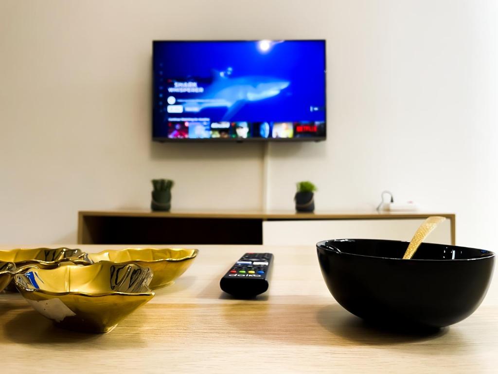 a wooden table with two bowls and a remote control at Cozy equipped apartment near train station facing Hilton luxury comfort in Tangier