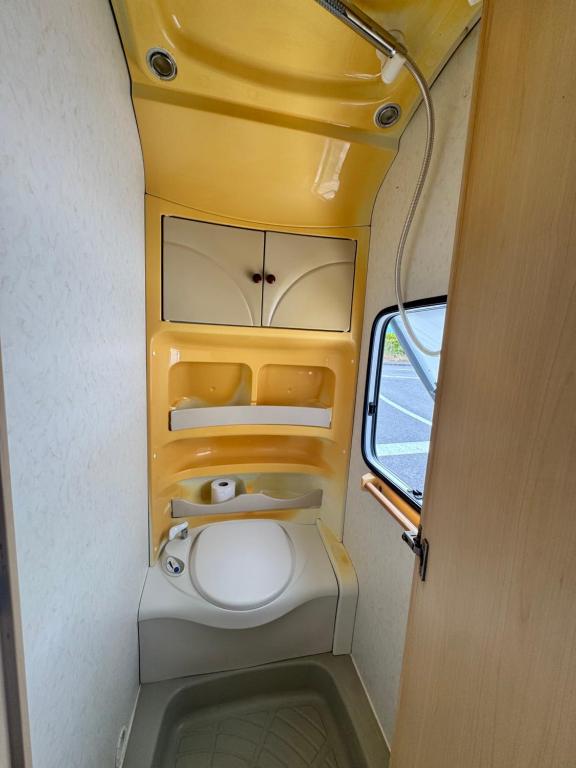 a small bathroom with a toilet in a vehicle at Caravana dintre nuci in Oradea