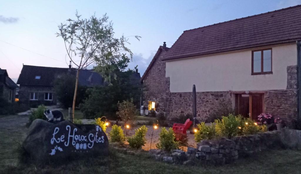 a stone sign in front of a house with lights at Rouge - 3 star ground floor apartment in Mantilly