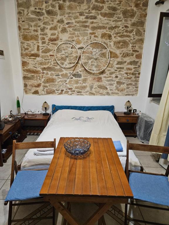 a room with a table and a bike on the wall at stone house classic in Ermoupoli