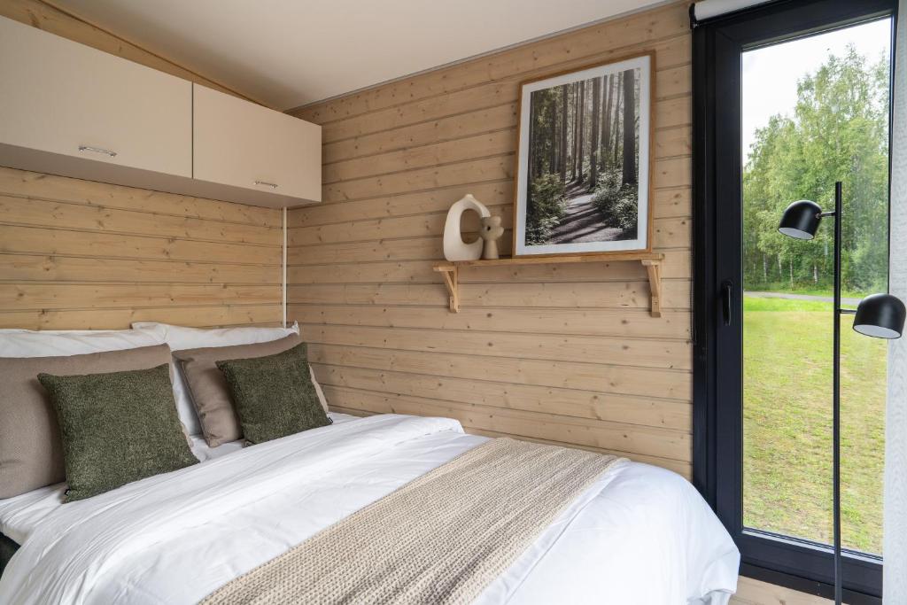 a bedroom with a bed and a window at Palas Experience Olkkajärvi Resort in Rovaniemi