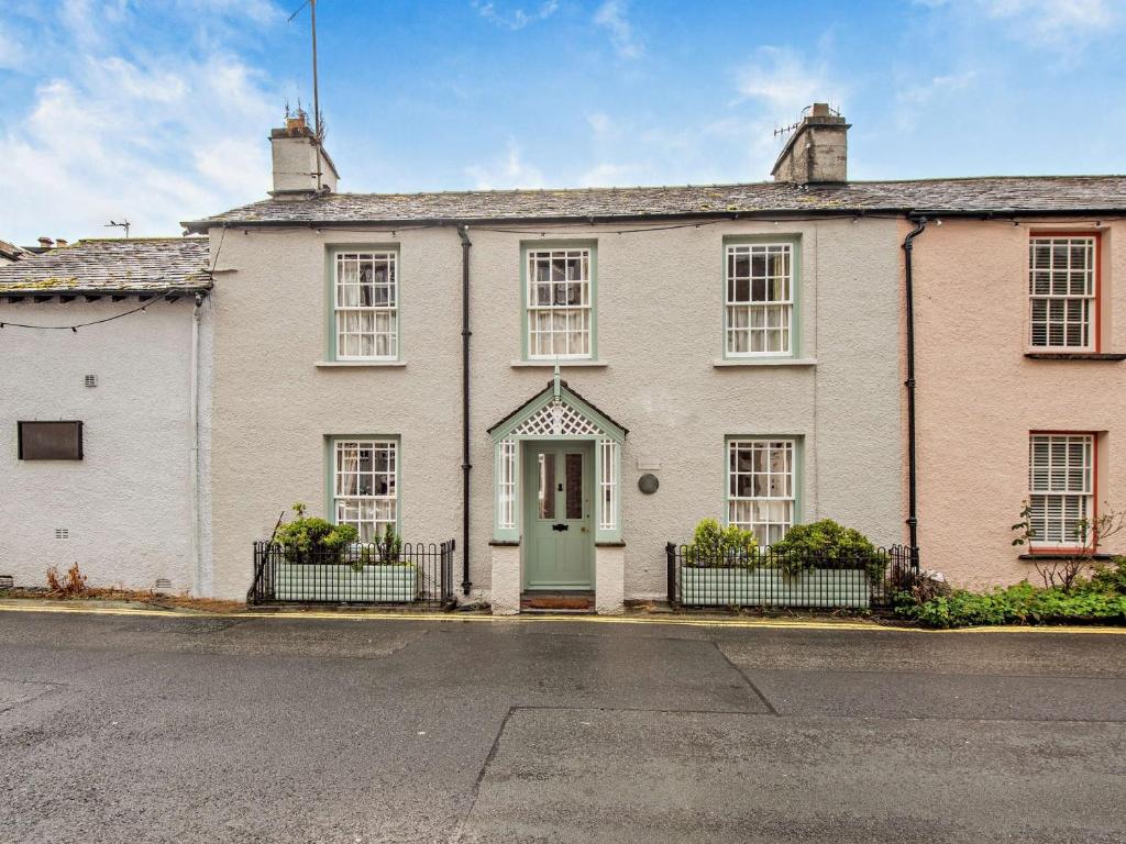 a white house with a green door on a street at 3 Bed in Hawkshead Village LLH34 in Hawkshead