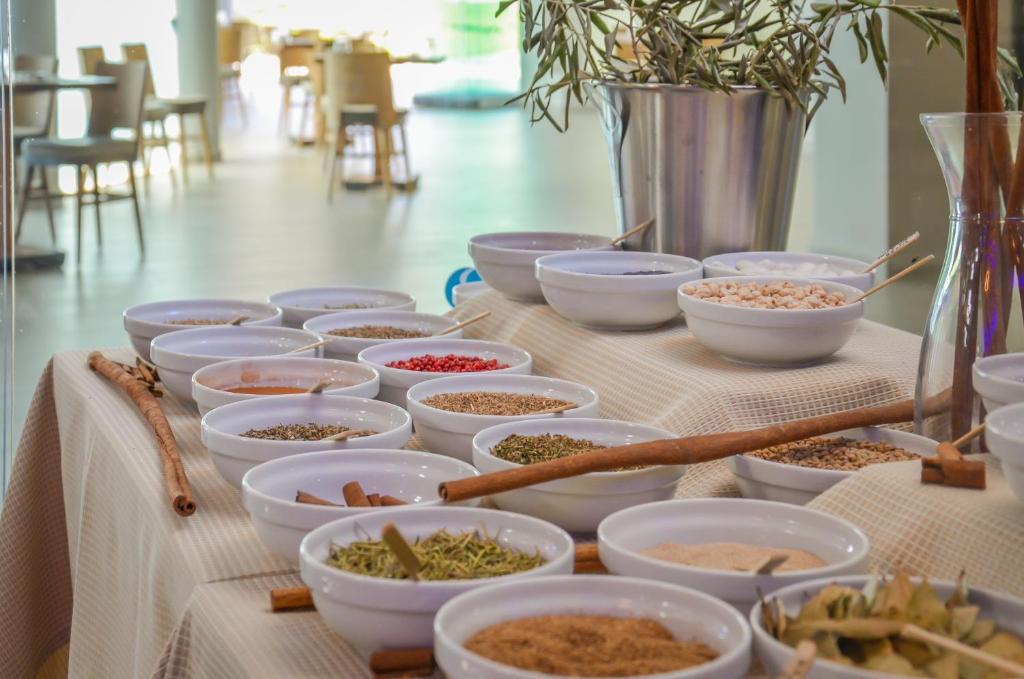 a table with bowls of food on a table at Thassos Imperial Resort in Skala Rachoniou