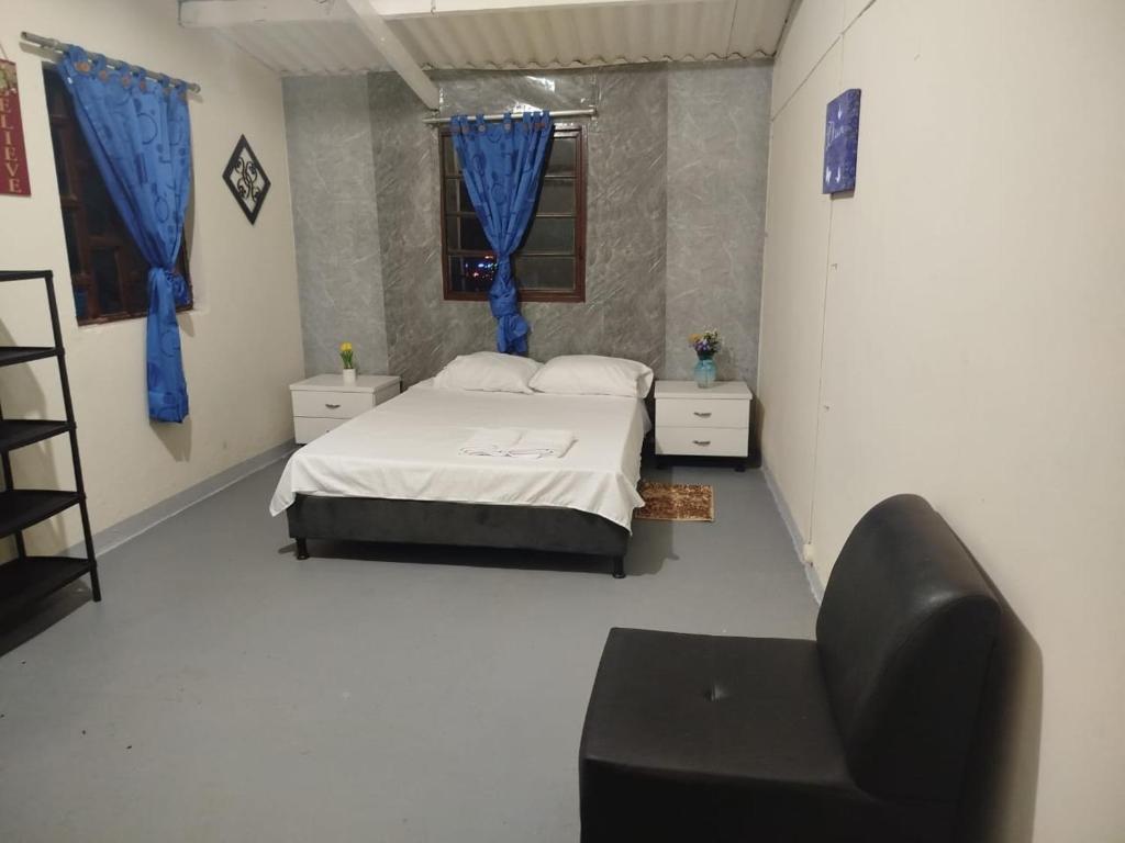 a bedroom with a bed and a chair in it at Eco-hostal Namaste in Salento