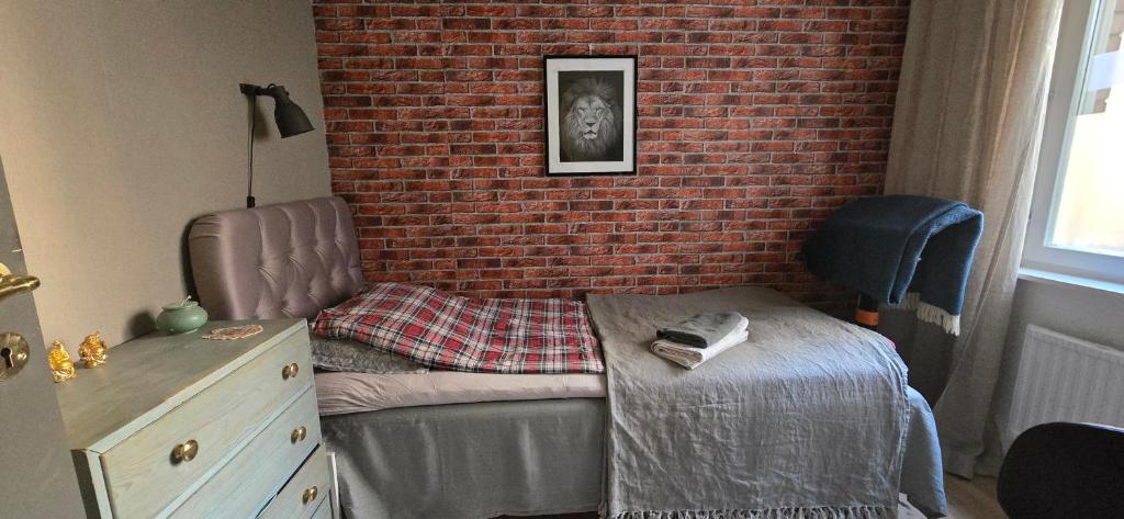 Un dormitorio con una cama y una pared de ladrillo. en Room best location Stockholm, en Estocolmo