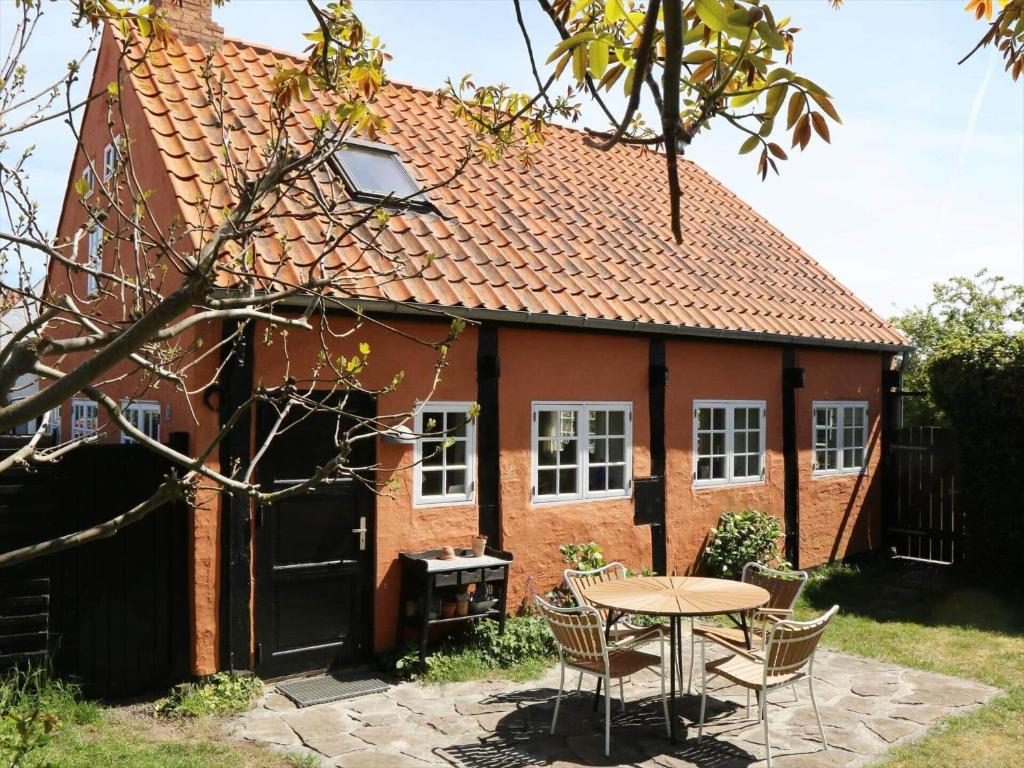 Una casa con una mesa y sillas delante de ella. en 5585-Svaneke-Helgolandsgade-7-B, en Svaneke