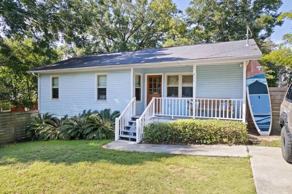 ein kleines weißes Haus mit einer Veranda und einem Hof in der Unterkunft Shem Shack-Old Village 5 mins to Beach in Charleston