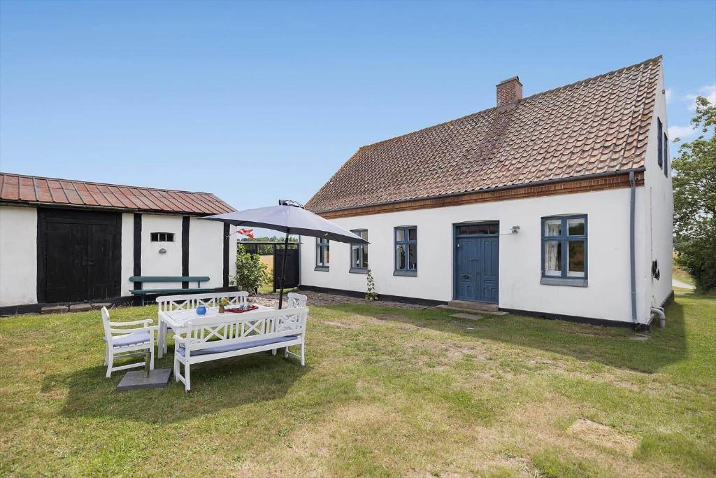a white house with a table and chairs in the yard at 6746-Hasle-Krakvej-3 in Hasle