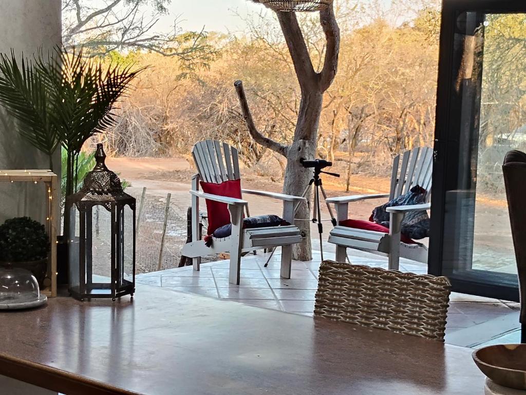 a room with three chairs and a table with a window at Edjami River View in Marloth Park