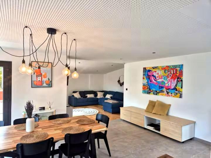 a living room with a dining table and a couch at Chez Simone Liège, bain nordique in Boncelles